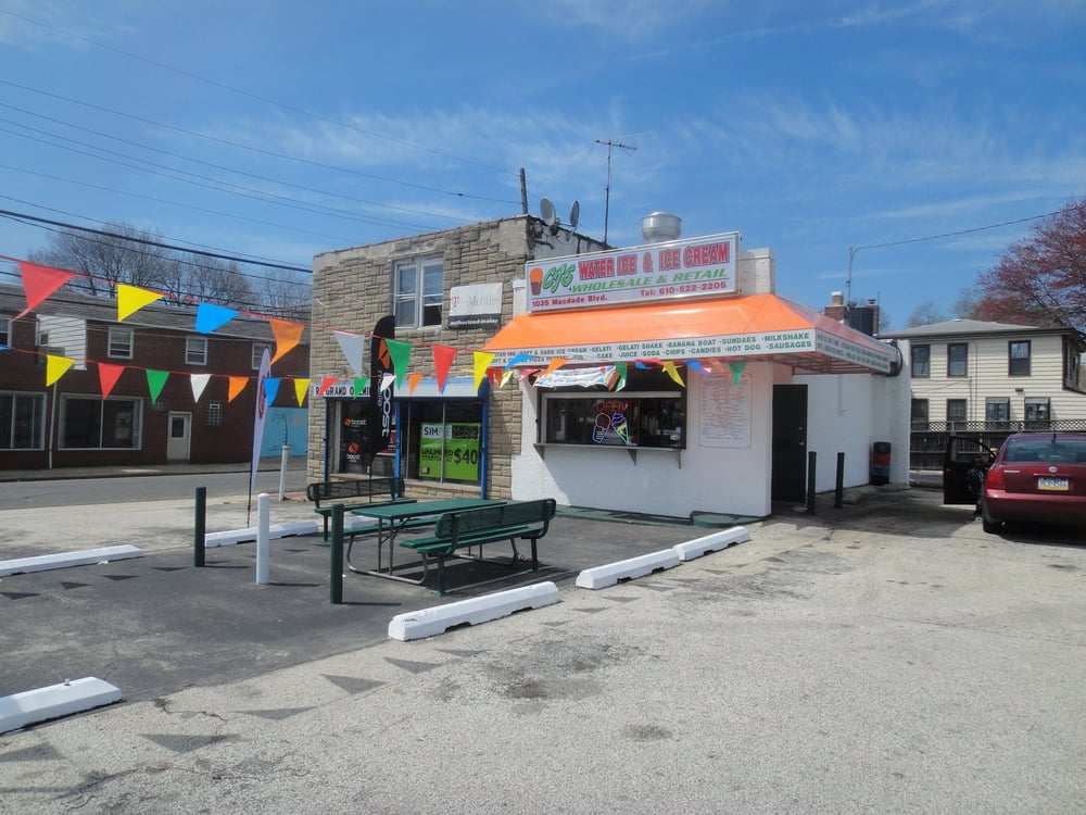 Wide exterior view of CJ's Waterice and Ice Cream with parking lot seating.